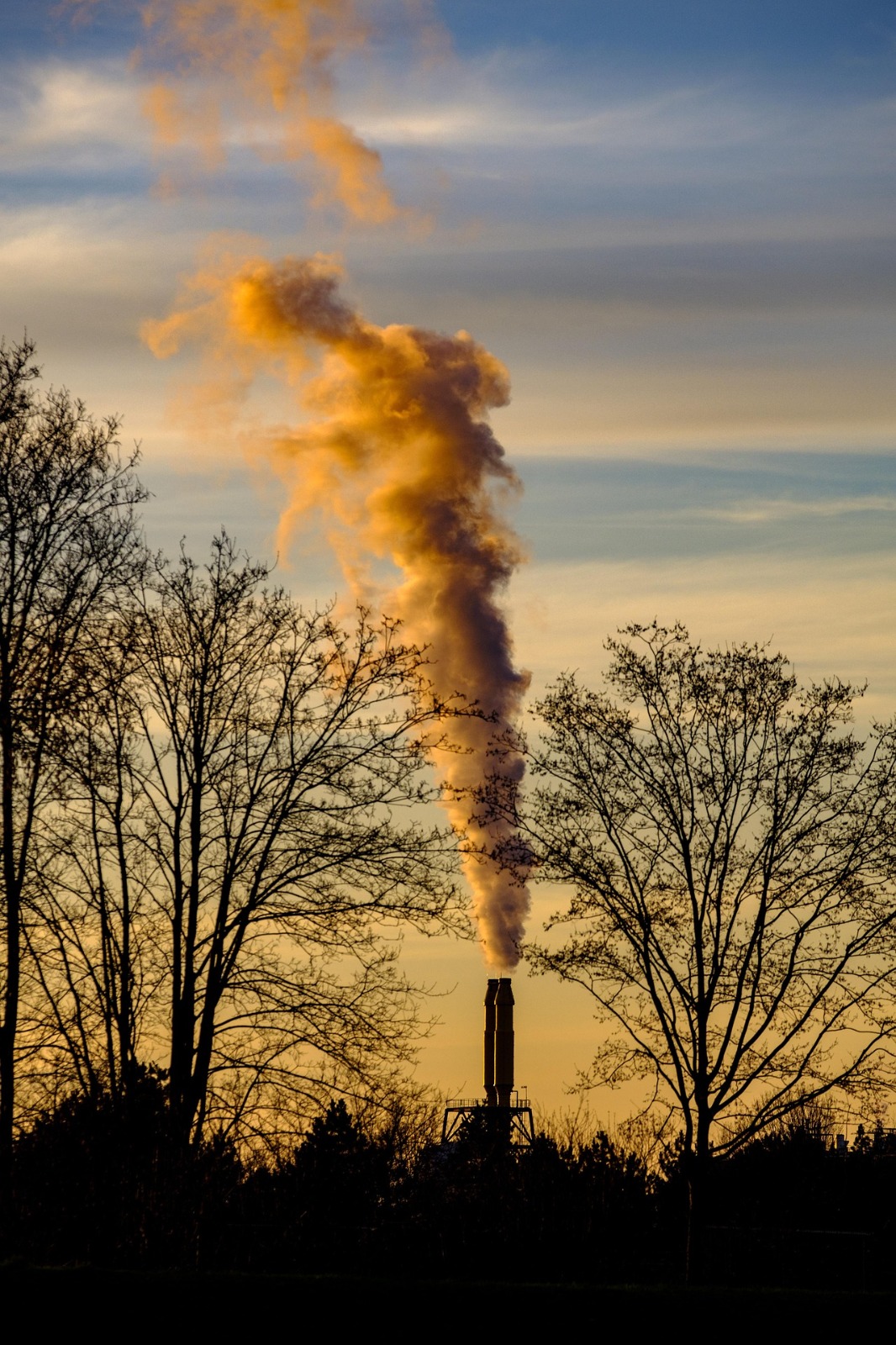 Industrial stack releasing visible smoke for air-emission monitoring context